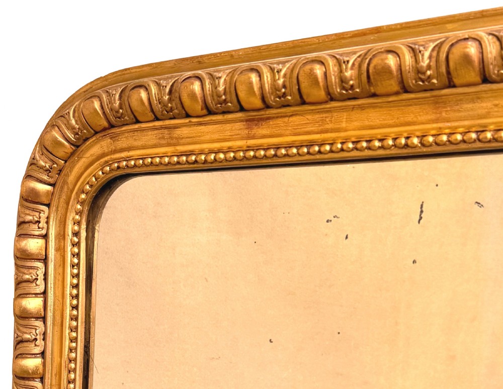 A 19th-century French rectangular wall mirror featuring a giltwood frame with rounded upper corners and beaded moulding detailing. View IV