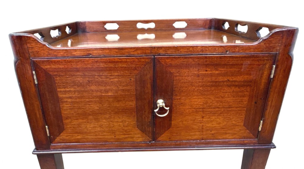 An 18th-century Georgian mahogany bedside table featuring a pierced tray top gallery with cut-out handles, double cupboard doors with a central brass pull, and square tapered legs. View XI