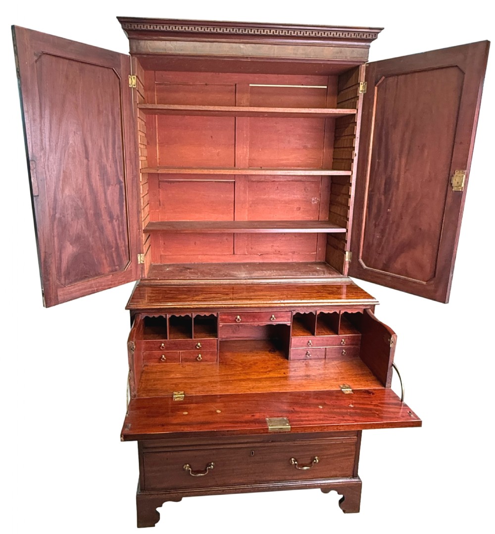 An 18th-century Chippendale mahogany cabinet on chest featuring upper cupboard doors with flame mahogany panels, a moulded cornice, and a lower section with four drawers on bracket feet. View III