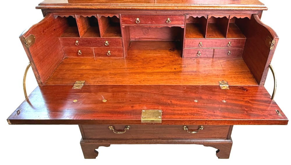 An 18th-century Chippendale mahogany cabinet on chest featuring upper cupboard doors with flame mahogany panels, a moulded cornice, and a lower section with four drawers on bracket feet. View VI