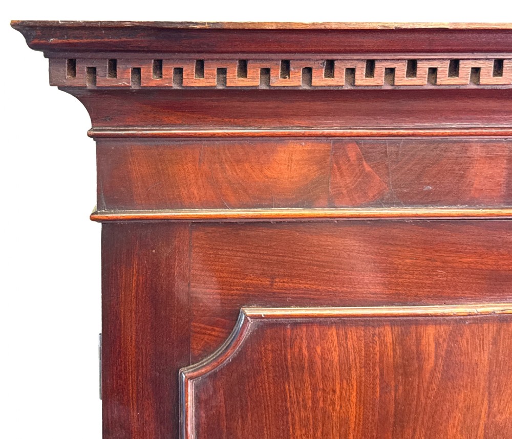 An 18th-century Chippendale mahogany cabinet on chest featuring upper cupboard doors with flame mahogany panels, a moulded cornice, and a lower section with four drawers on bracket feet. View XII