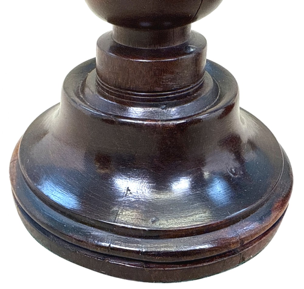A pair of 19th-century turned lignum vitae wooden candlesticks featuring baluster-form stems, stepped circular bases, and contrasting dark and light graining. View V