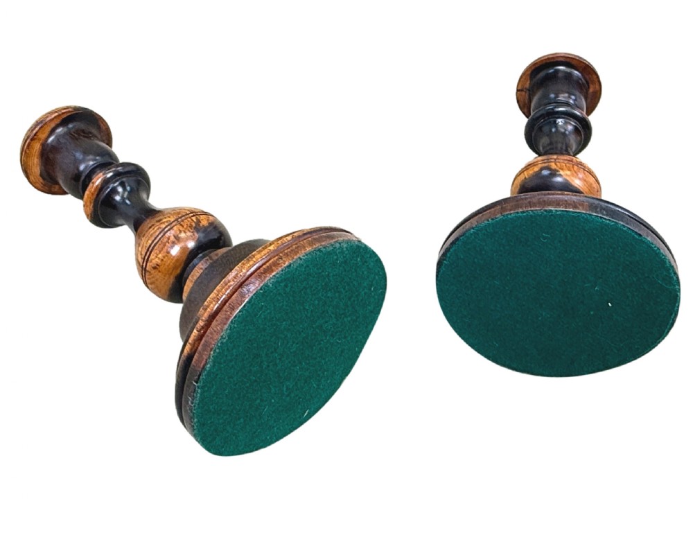 A pair of 19th-century turned lignum vitae wooden candlesticks featuring baluster-form stems, stepped circular bases, and contrasting dark and light graining. View VIII
