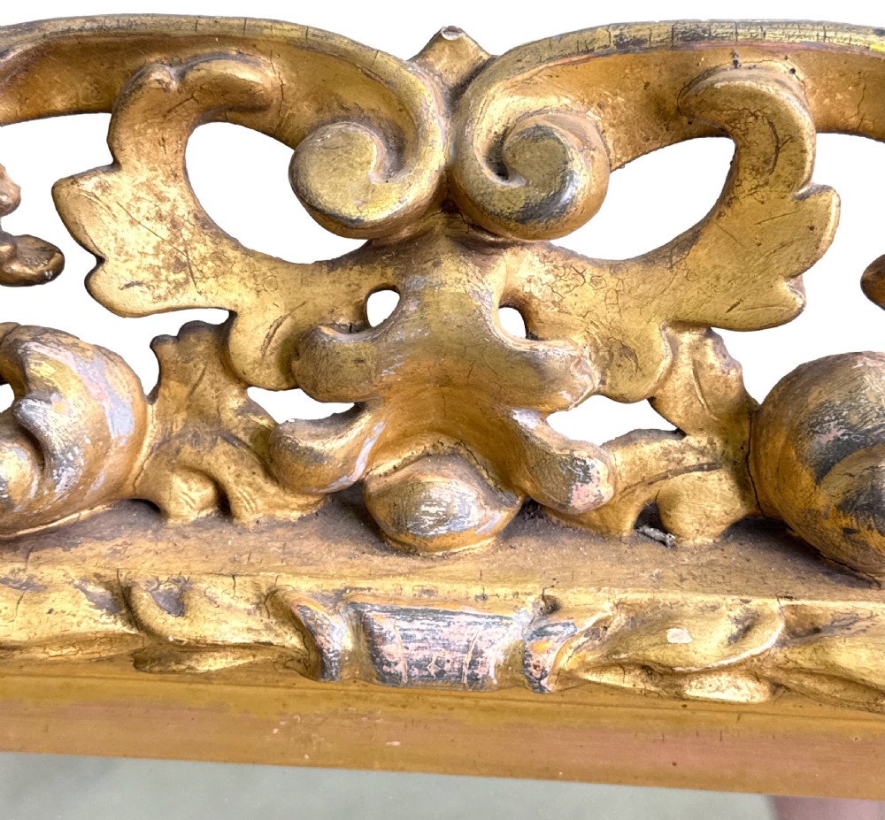 An early nineteenth-century rectangular Florentine wall mirror featuring an intricately carved foliage giltwood frame surrounding a rectangular glass plate. View III