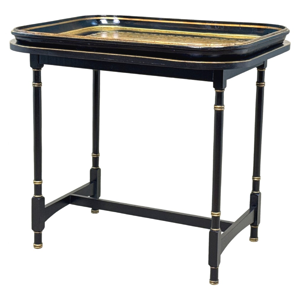 A 19th-century black papier-mache tray featuring gilded rim decoration, resting on a black turned wooden stand with gold accent rings.