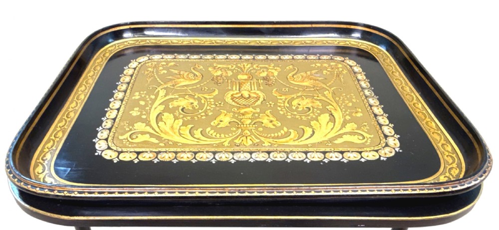 A 19th-century black papier-mache tray featuring gilded rim decoration, resting on a black turned wooden stand with gold accent rings. View VII