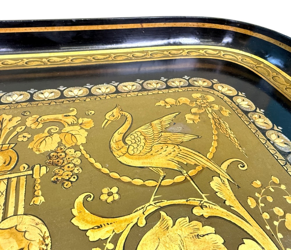 A 19th-century black papier-mache tray featuring gilded rim decoration, resting on a black turned wooden stand with gold accent rings. View X