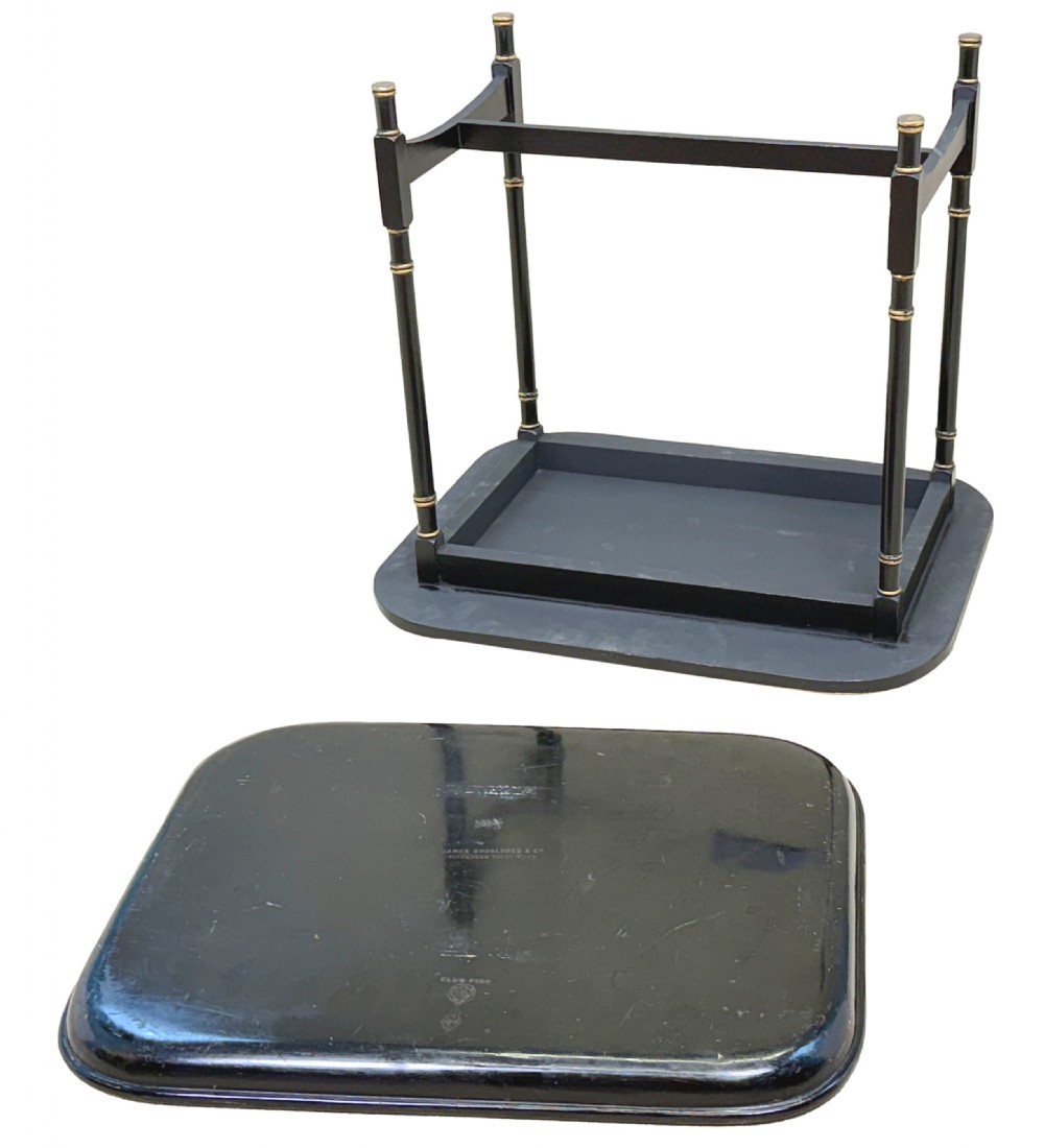 A 19th-century black papier-mache tray featuring gilded rim decoration, resting on a black turned wooden stand with gold accent rings. View XII
