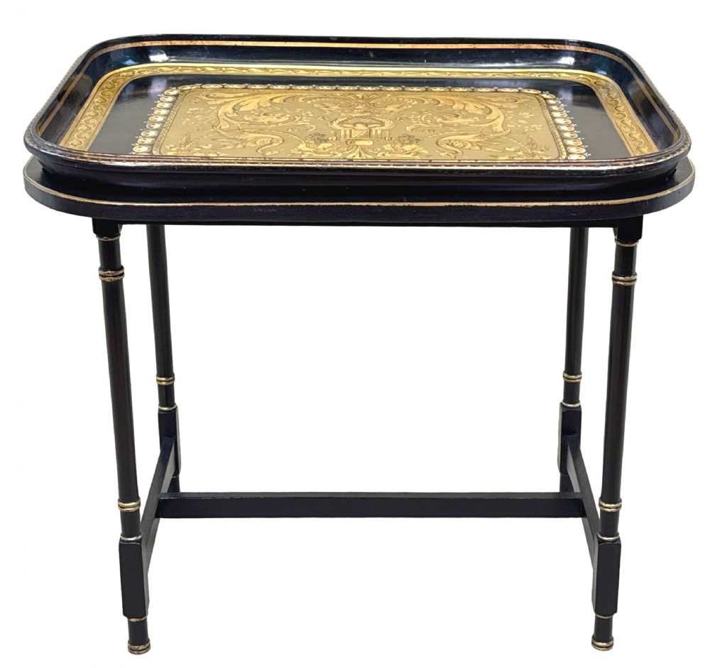 A 19th-century black papier-mache tray featuring gilded rim decoration, resting on a black turned wooden stand with gold accent rings. View XIII