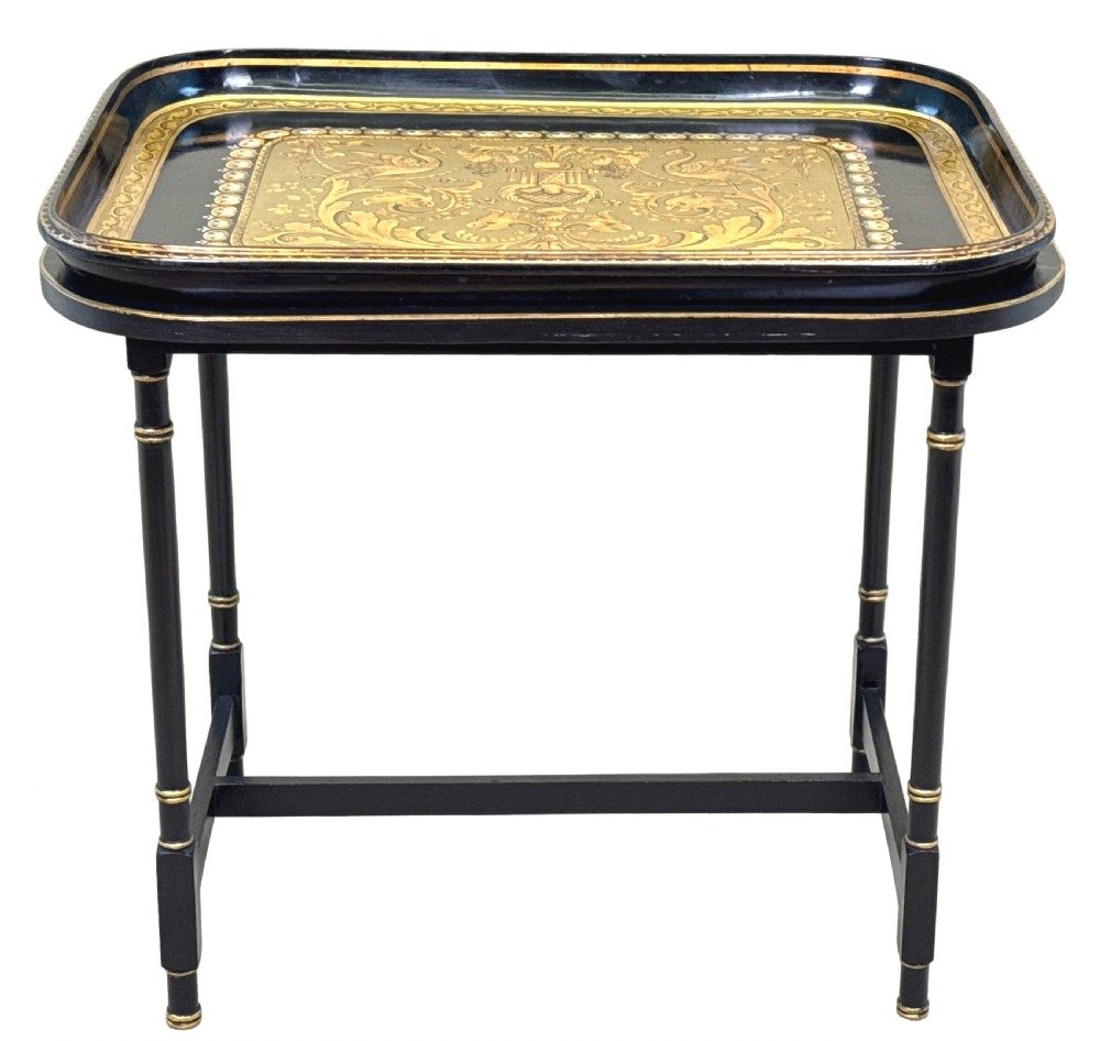 A 19th-century black papier-mache tray featuring gilded rim decoration, resting on a black turned wooden stand with gold accent rings. View XV