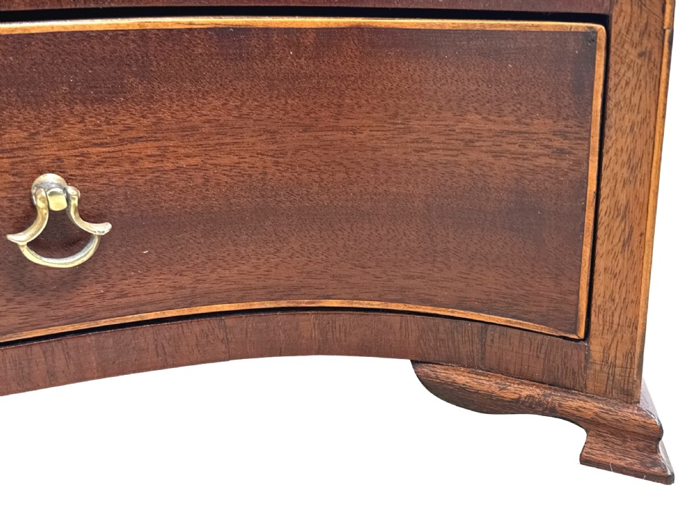 A Georgian mahogany dressing table mirror featuring a shield-shaped frame supported by curved uprights over a serpentine base with a single drawer. View V