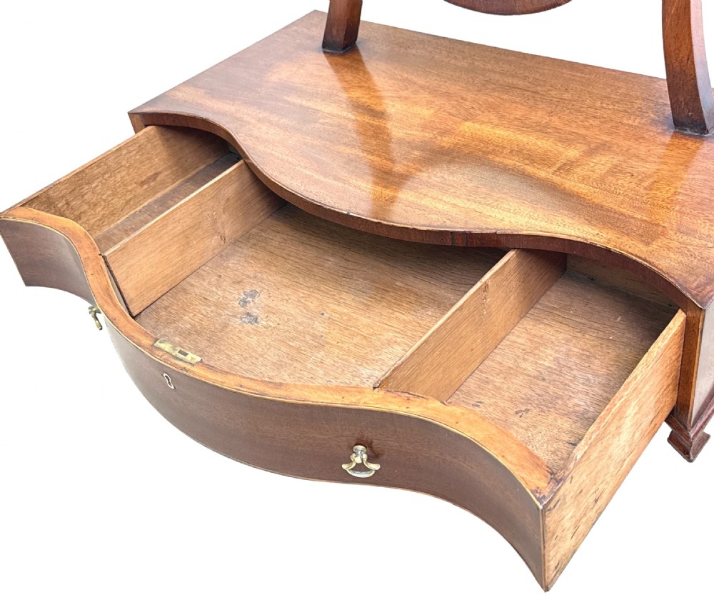 A Georgian mahogany dressing table mirror featuring a shield-shaped frame supported by curved uprights over a serpentine base with a single drawer. View XIII