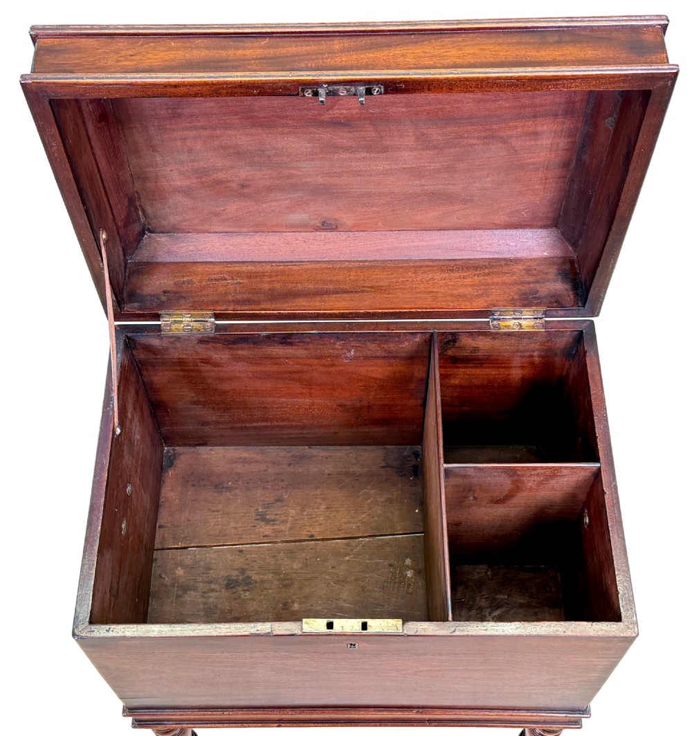 A Georgian mahogany cellarette on turned legs with brass castors, lion mask side handles, and a hinged moulded lid. View VII