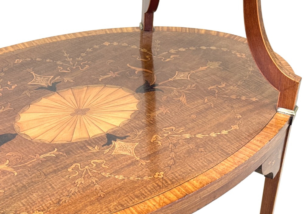 A 19th-century oval two-tier mahogany table featuring satinwood marquetry inlay, a scalloped top tier gallery with brass handles, and curved legs. View VIII
