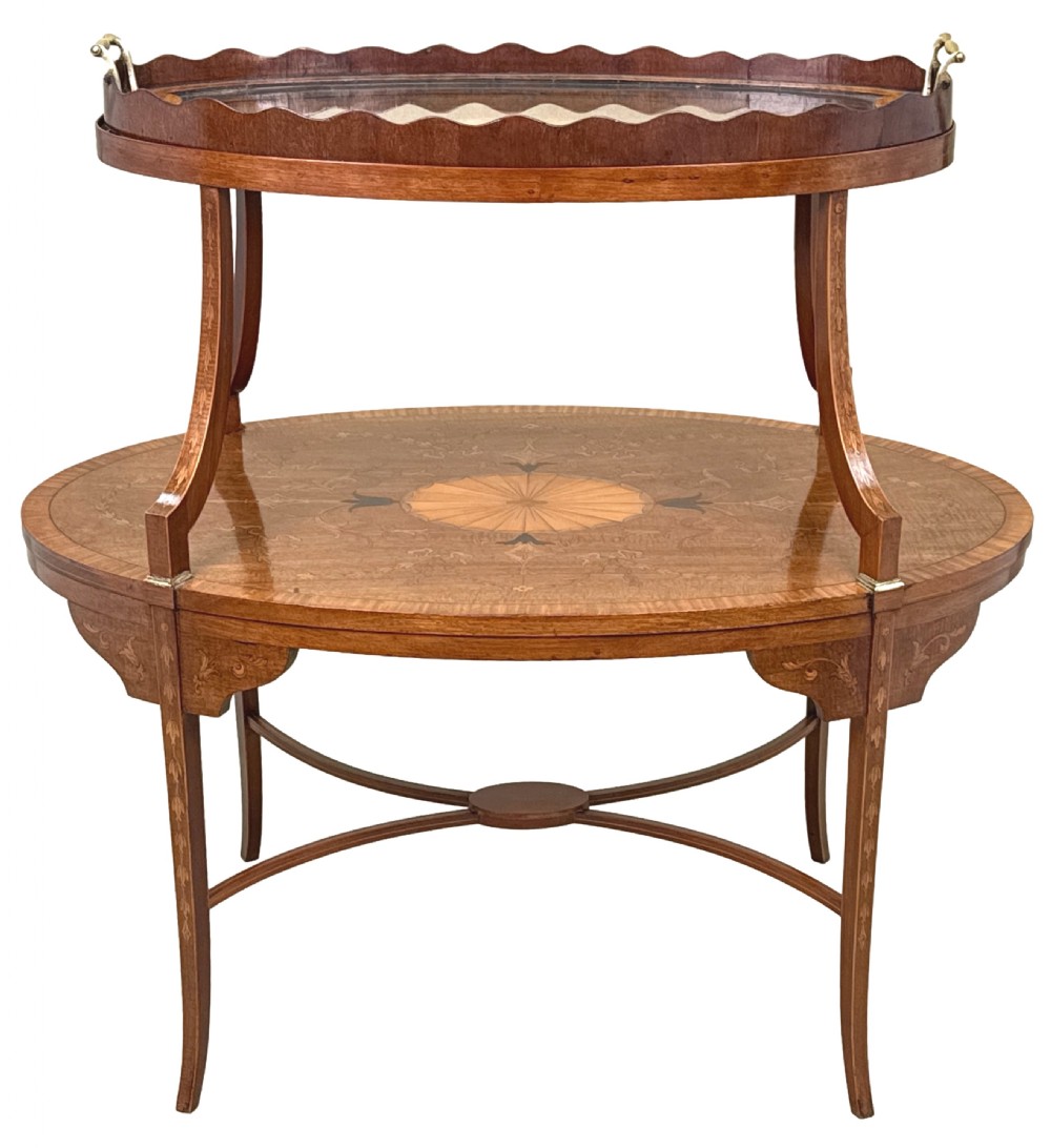 A 19th-century oval two-tier mahogany table featuring satinwood marquetry inlay, a scalloped top tier gallery with brass handles, and curved legs. View XIV