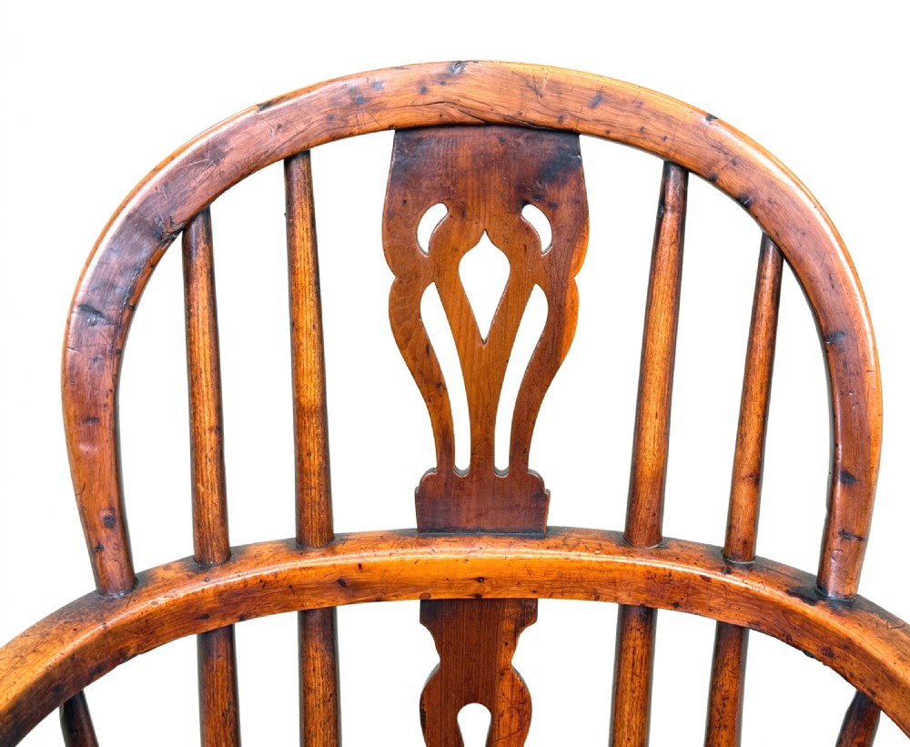 A 19th-century childs Windsor armchair crafted from yew wood, featuring a hoop back with a pierced fretwork splat, turned legs, and a curved stretcher. View III