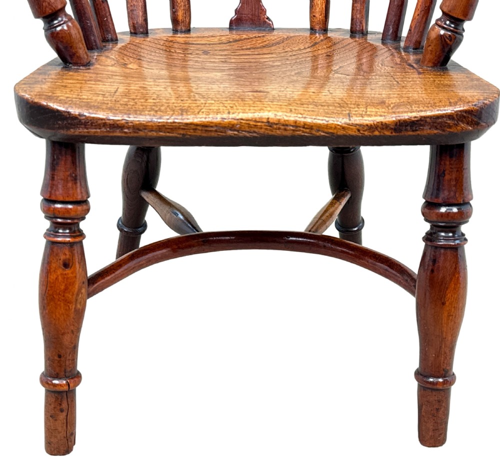 A 19th-century childs Windsor armchair crafted from yew wood, featuring a hoop back with a pierced fretwork splat, turned legs, and a curved stretcher. View VIII