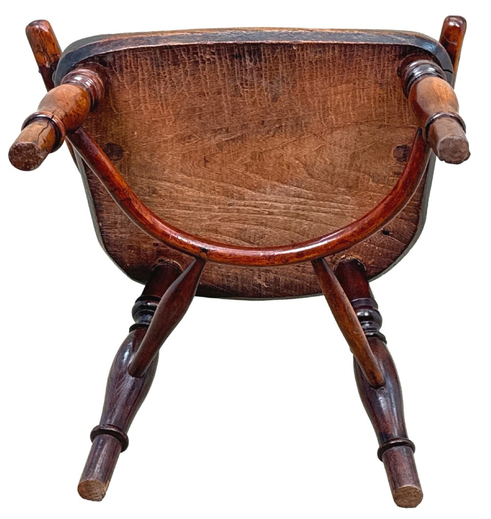 A 19th-century childs Windsor armchair crafted from yew wood, featuring a hoop back with a pierced fretwork splat, turned legs, and a curved stretcher. View X
