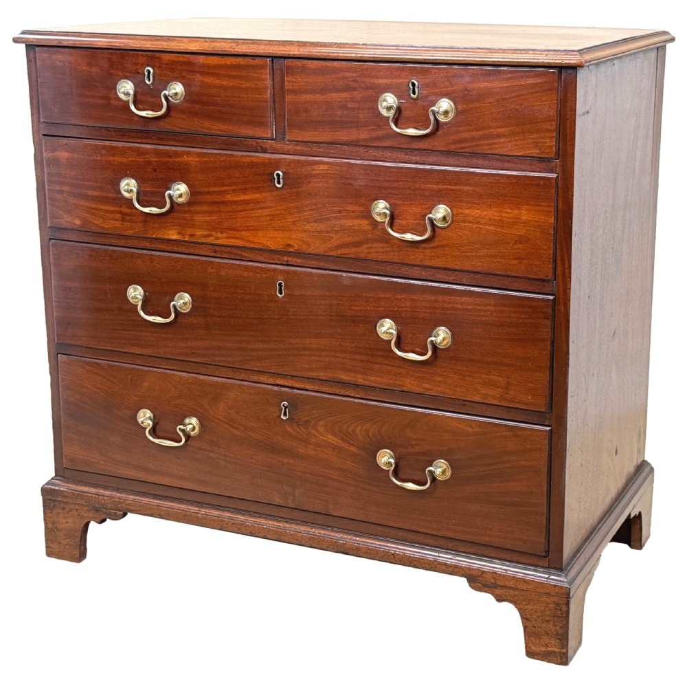 A George III mahogany chest of drawers featuring two short drawers over three long graduated drawers with brass swan-neck handles and bracket feet. View VI