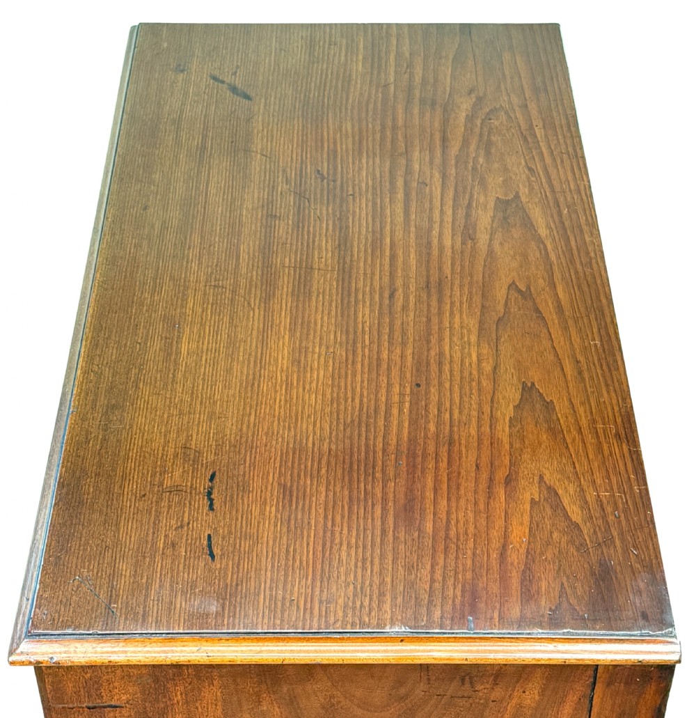 A George III mahogany chest of drawers featuring two short drawers over three long graduated drawers with brass swan-neck handles and bracket feet. View VII