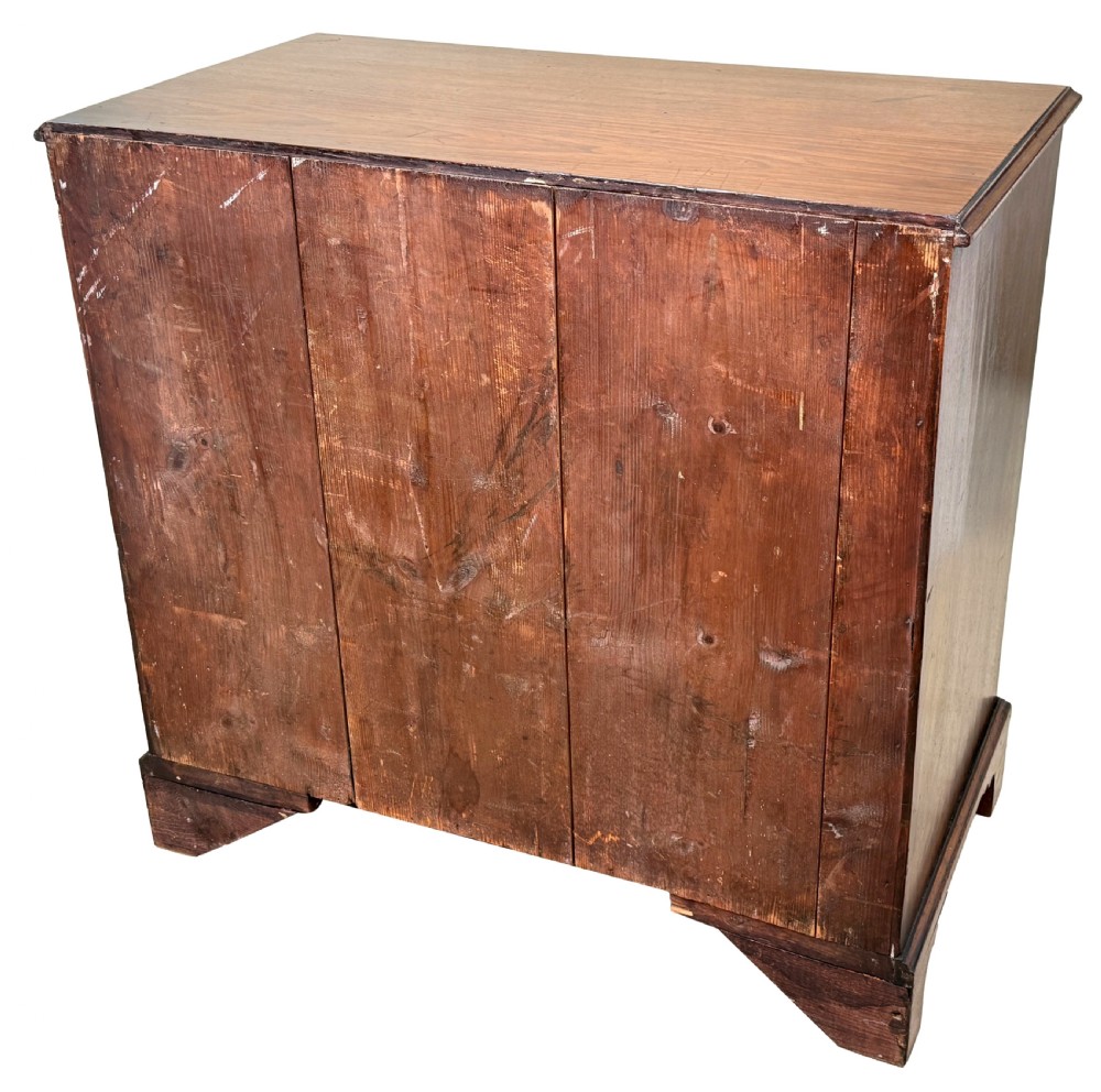 A George III mahogany chest of drawers featuring two short drawers over three long graduated drawers with brass swan-neck handles and bracket feet. View X