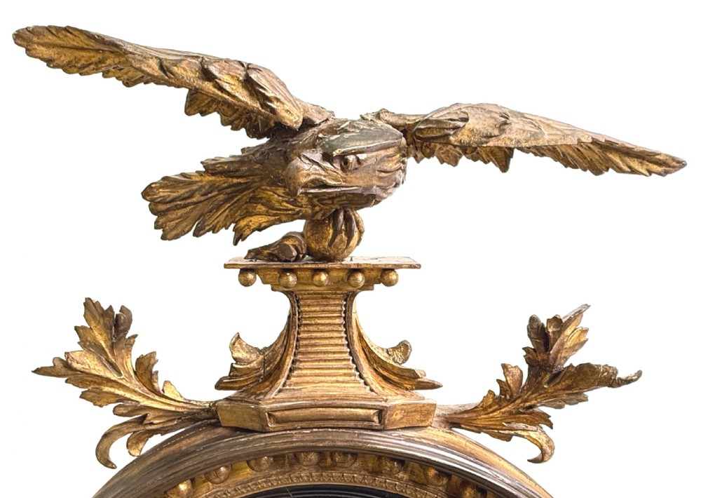 A circular Regency giltwood convex mirror with a carved eagle cresting, ball ornamentation along the frame, and acanthus leaf apron. View VI