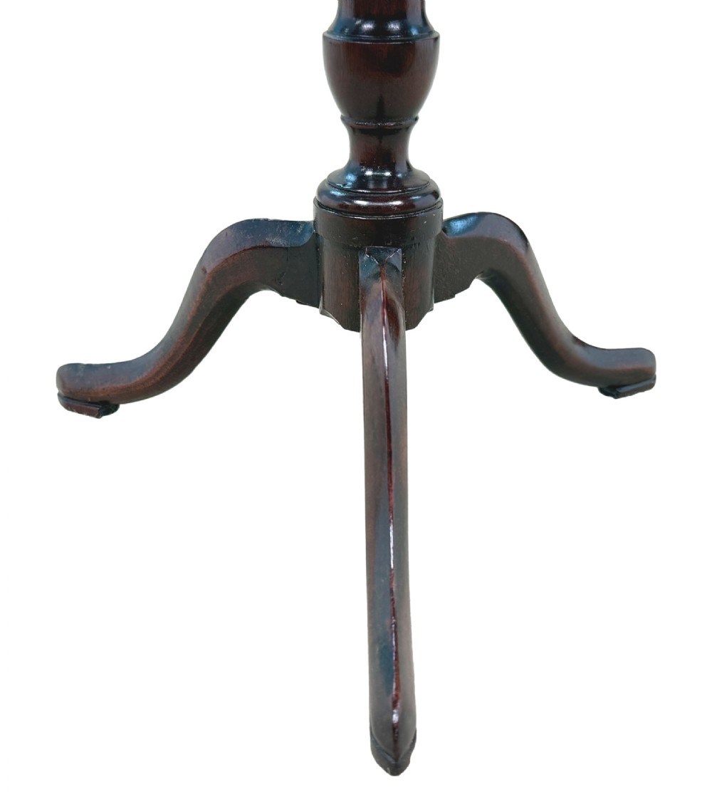An 18th-century Georgian miniature mahogany tripod table featuring a round top, turned central stem, and three cabriole legs. View V
