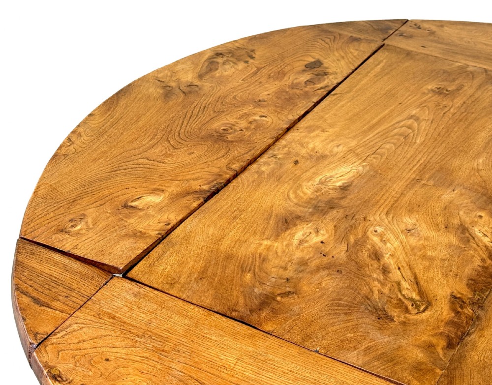 A nineteenth-century French Provincial elm centre table featuring a round top with two drop leaves, a turned central pedestal, and a three-legged tripod base. View V