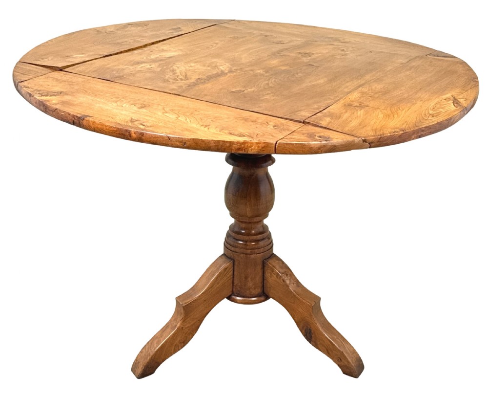 A nineteenth-century French Provincial elm centre table featuring a round top with two drop leaves, a turned central pedestal, and a three-legged tripod base. View VI