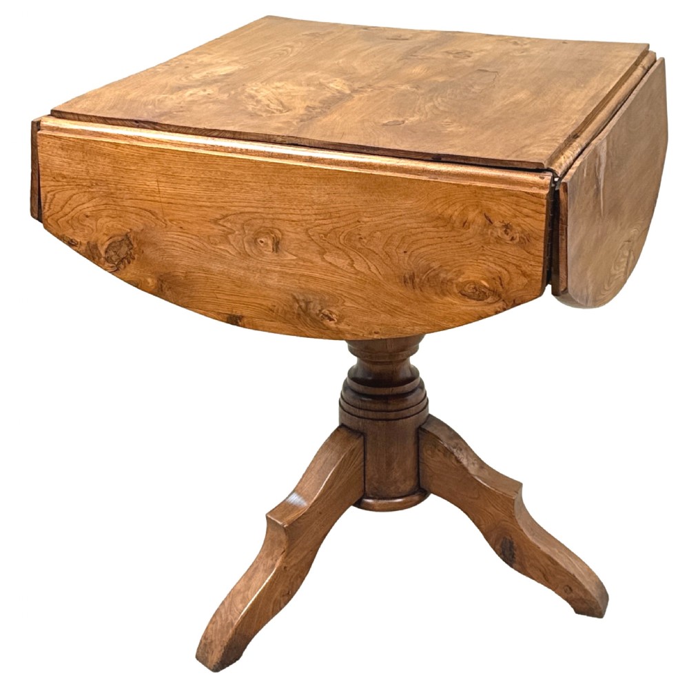 A nineteenth-century French Provincial elm centre table featuring a round top with two drop leaves, a turned central pedestal, and a three-legged tripod base. View X