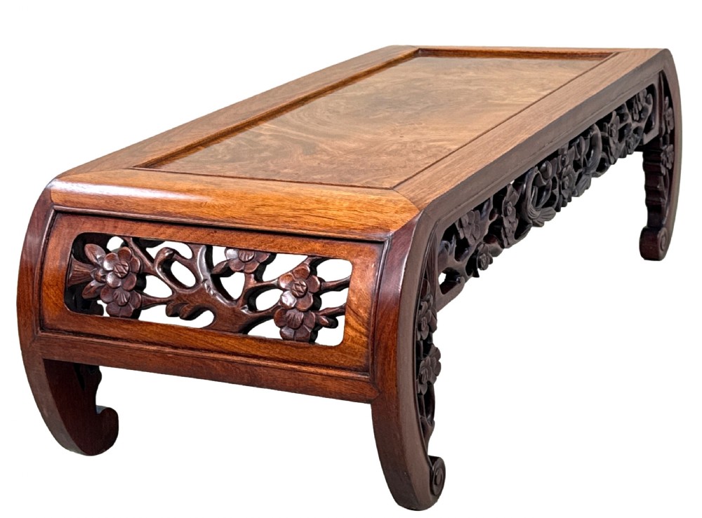 A low-profile 19th-century Oriental hardwood coffee table featuring an intricately carved floral apron and inwardly curved scroll legs. View IV