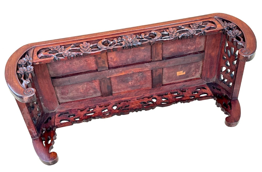 A low-profile 19th-century Oriental hardwood coffee table featuring an intricately carved floral apron and inwardly curved scroll legs. View VIII