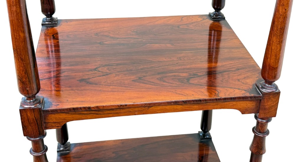 A three-tier Regency rosewood whatnot stand featuring slender turned column supports, decorative top corner finials, and brass castors. View VIII