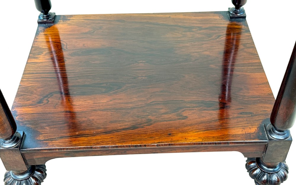 A three-tier Regency rosewood whatnot stand featuring slender turned column supports, decorative top corner finials, and brass castors. View X