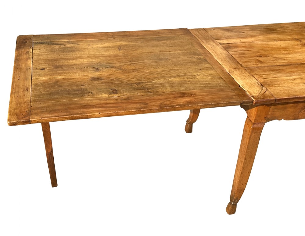 An early 19th-century warm brown extending farmhouse dining table with two end pull-out extensions supported by additional legs. View X