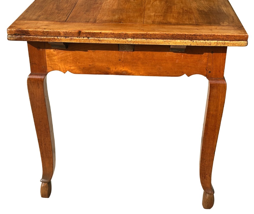 An early 19th-century warm brown extending farmhouse dining table with two end pull-out extensions supported by additional legs. View XX