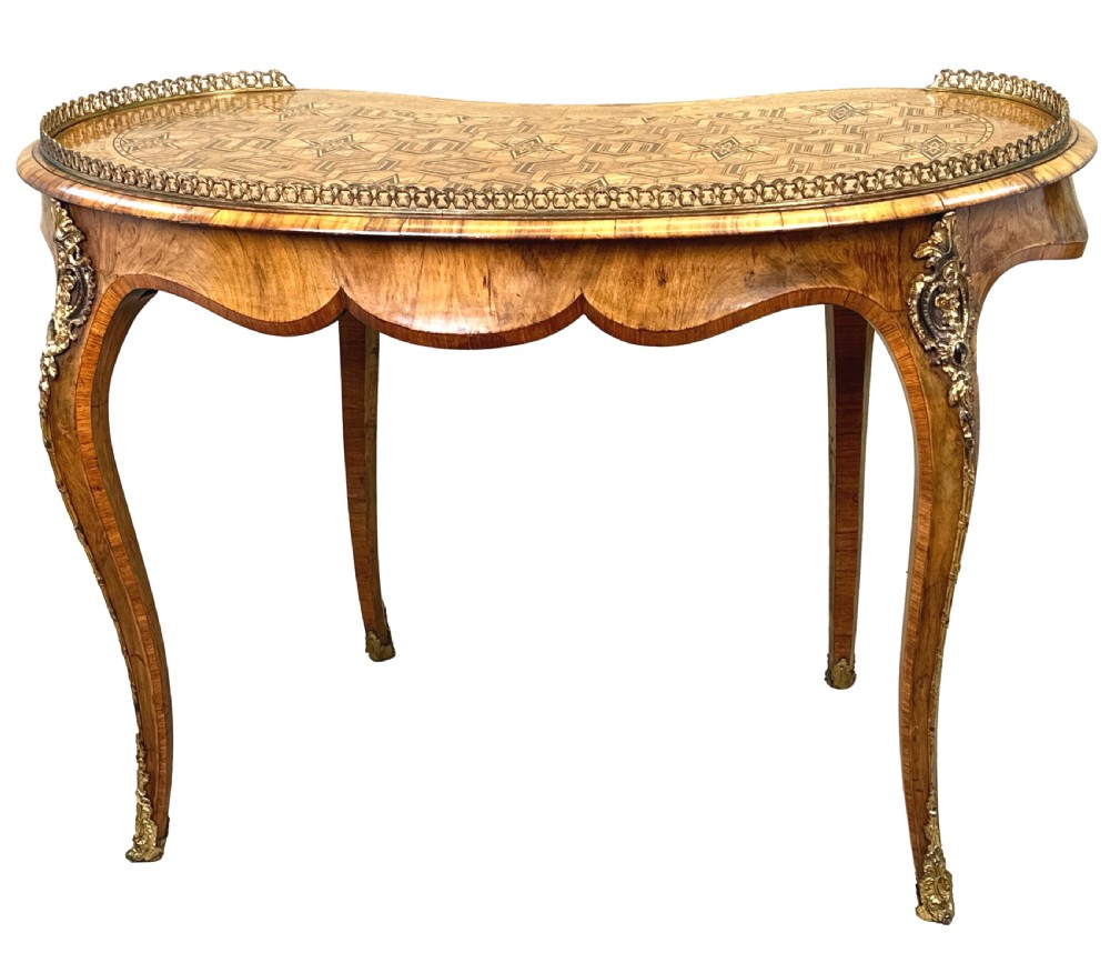 A 19th-century kidney-shaped burr walnut table featuring marquetry inlay, cabriole legs, and brass ormolu mounts with a pierced gallery edge. View X