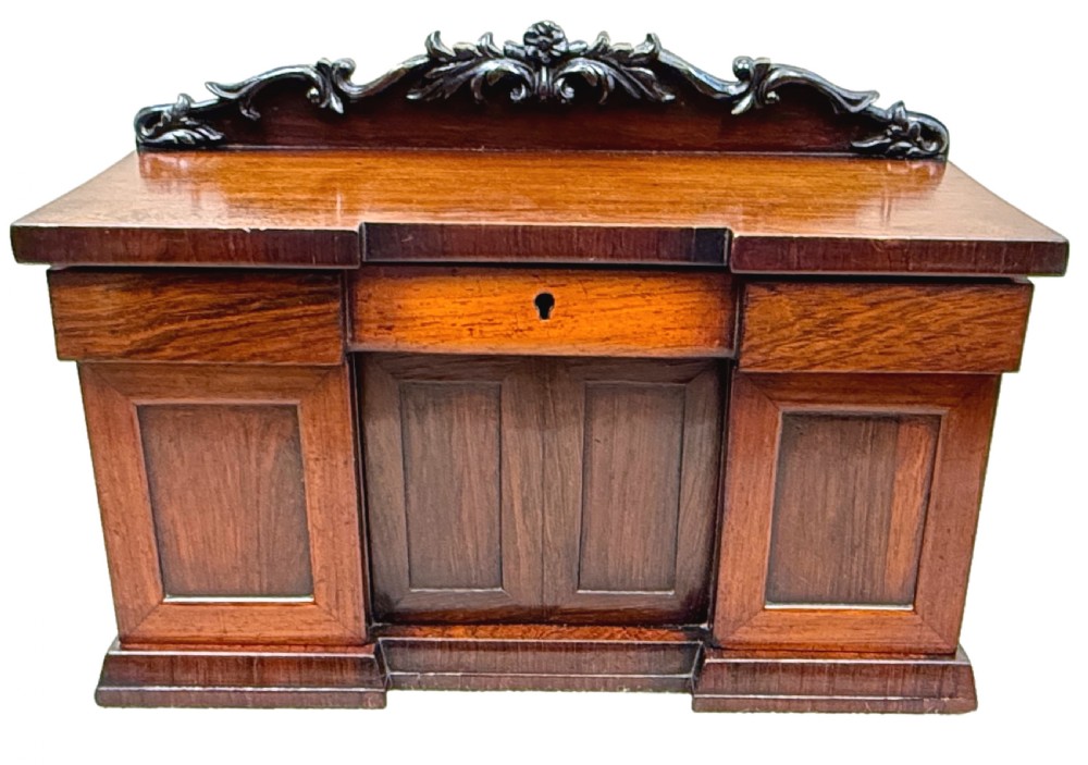 A dark rosewood tea caddy crafted in the shape of a miniature Regency breakfront sideboard with a carved cresting backboard. View XI