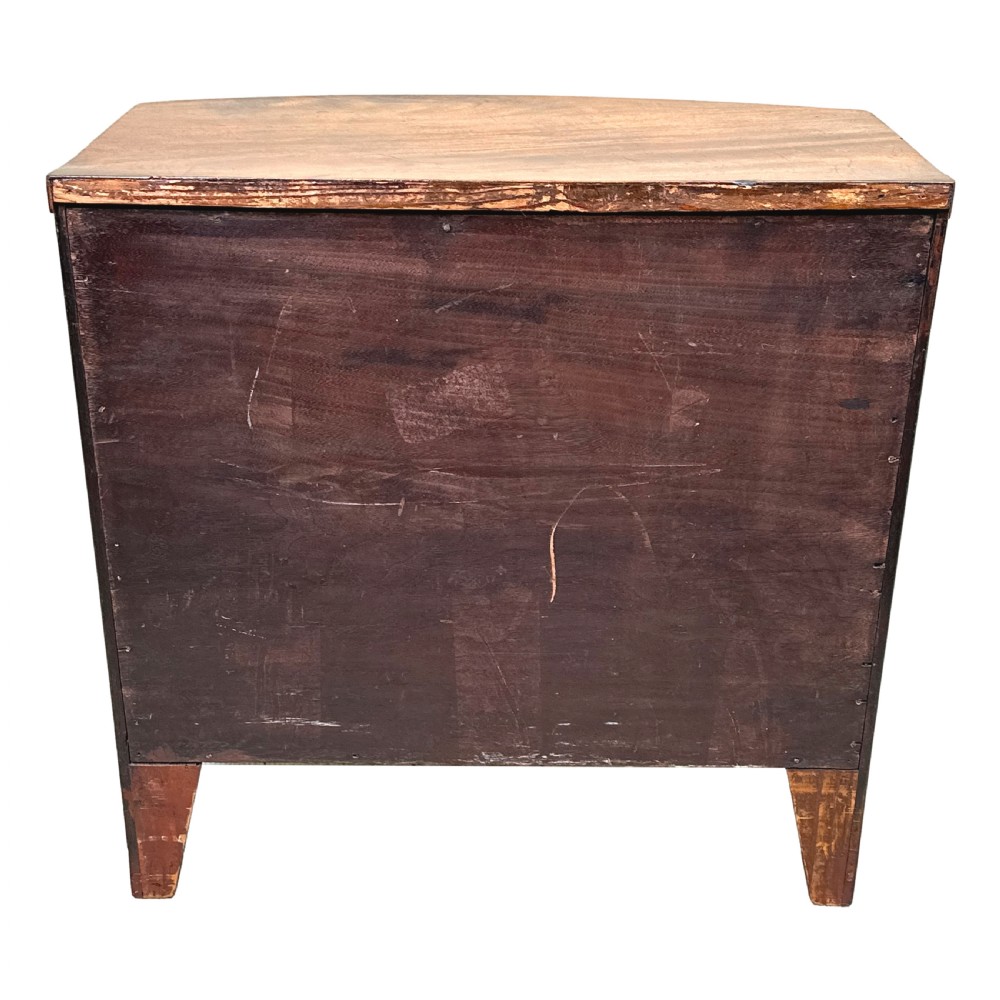 A Georgian mahogany miniature bowfront chest of drawers with flame mahogany drawer fronts, turned brass handles, and splayed bracket feet. View VII