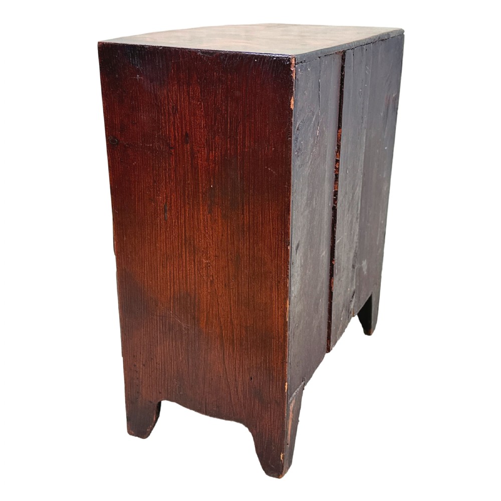 A Victorian miniature mahogany bowfront chest featuring two short over two long drawers with turned wooden knobs and bracket feet. View VII