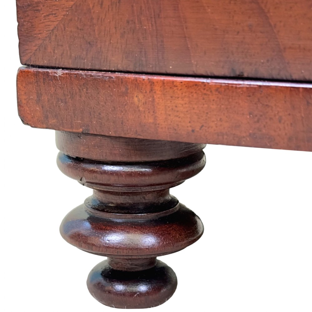 A Regency flame mahogany twin-door miniature table cabinet with turned feet, bead moulding, and brass escutcheons. View VIII
