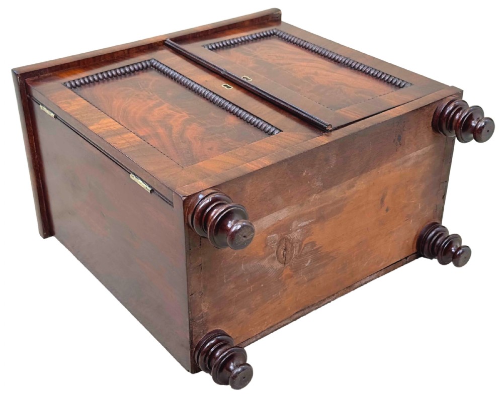 A Regency flame mahogany twin-door miniature table cabinet with turned feet, bead moulding, and brass escutcheons. View X