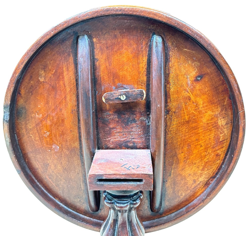 A mid-19th-century miniature circular mahogany centre table featuring a turned central column and a triform base with carved feet. View IX