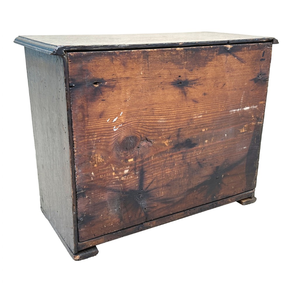 A dark oak miniature kneehole desk featuring a single top drawer over six side drawers and a central cupboard with a key and brass knobs. View VIII