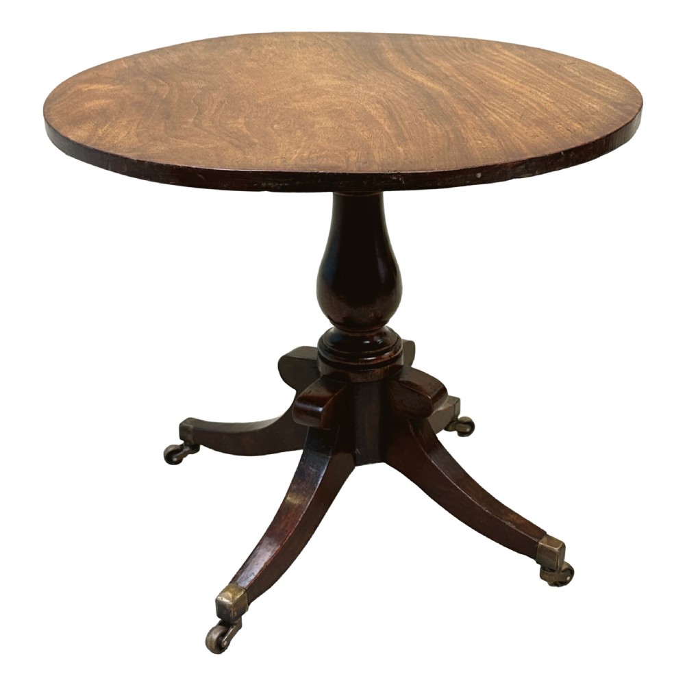 A Regency style miniature mahogany breakfast table with a circular tilt top, a central turned pedestal, and four splayed legs fitted with brass castors. View IV