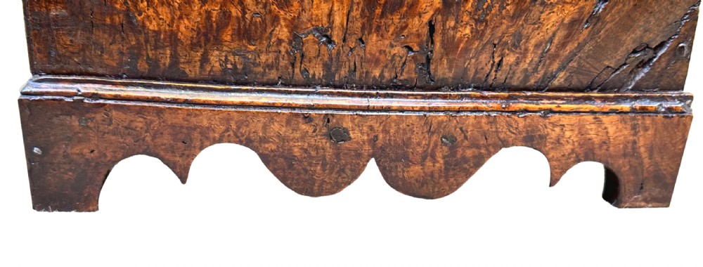 An 18th-century Georgian tabletop bureau made of dark warm elm wood, featuring a sloped writing flap above three drawers with brass ring pulls and a scalloped base. View VI