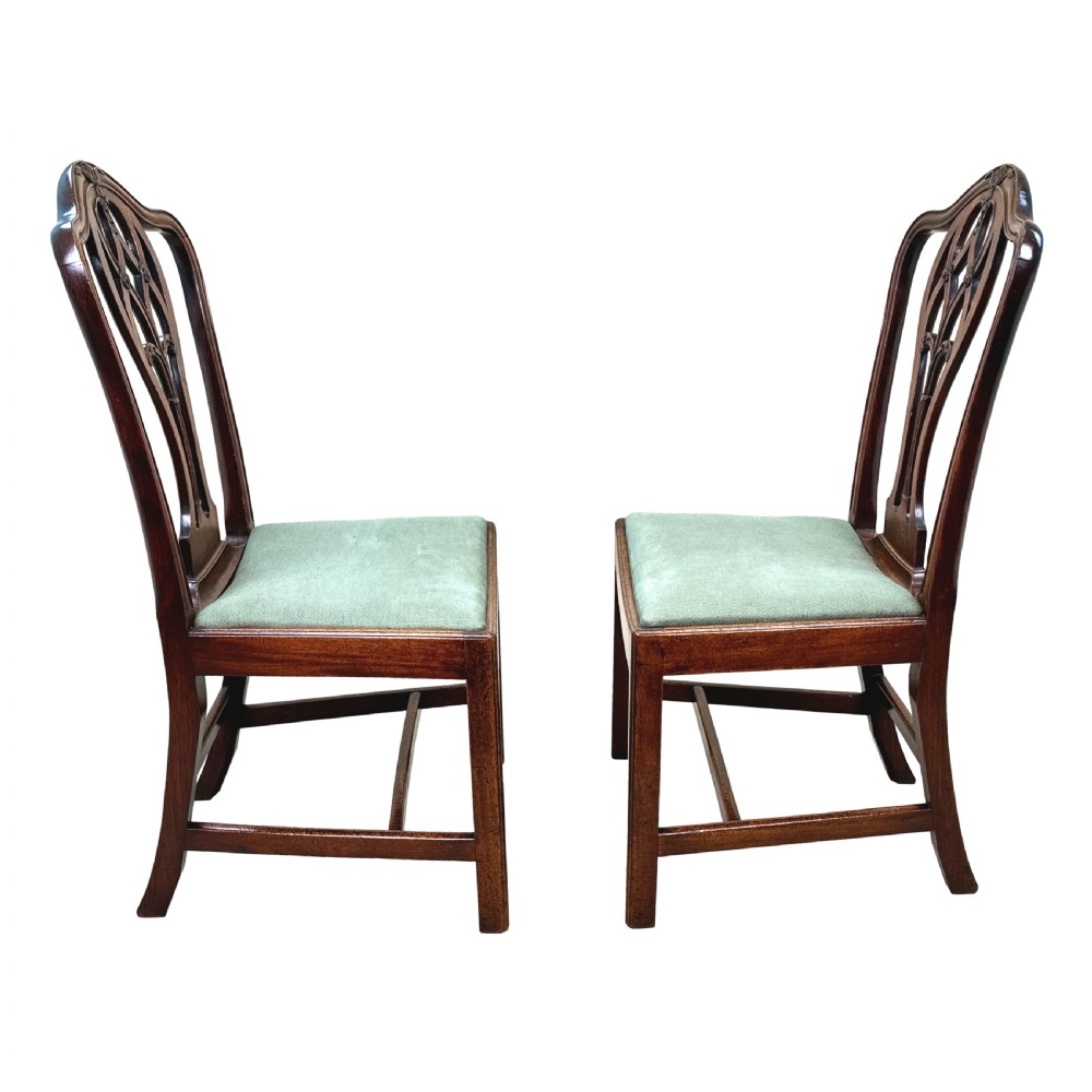 A pair of 18th-century Georgian mahogany side chairs featuring pierced back splats, serpentine top rails, and light green upholstered drop-in seats. View IV