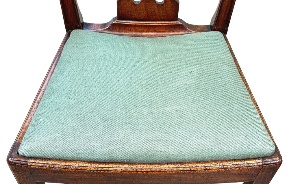 A pair of 18th-century Georgian mahogany side chairs featuring pierced back splats, serpentine top rails, and light green upholstered drop-in seats. View VI