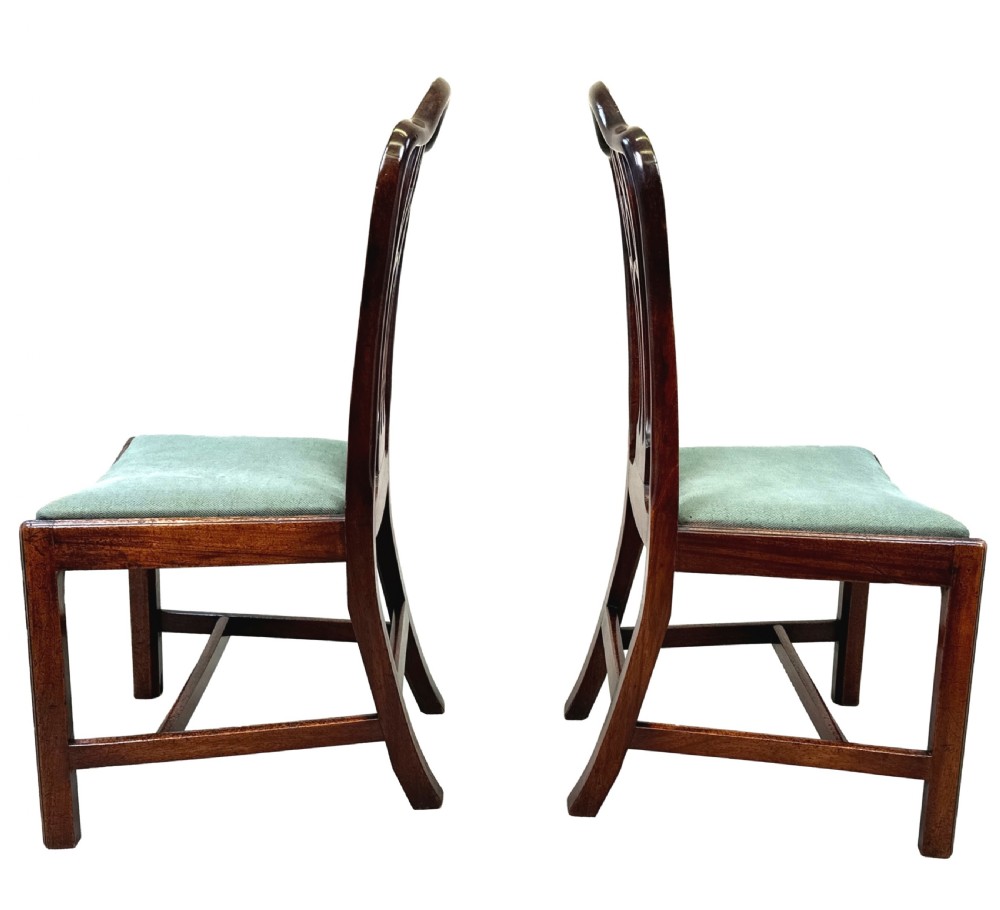 A pair of 18th-century Georgian mahogany side chairs featuring pierced back splats, serpentine top rails, and light green upholstered drop-in seats. View VII
