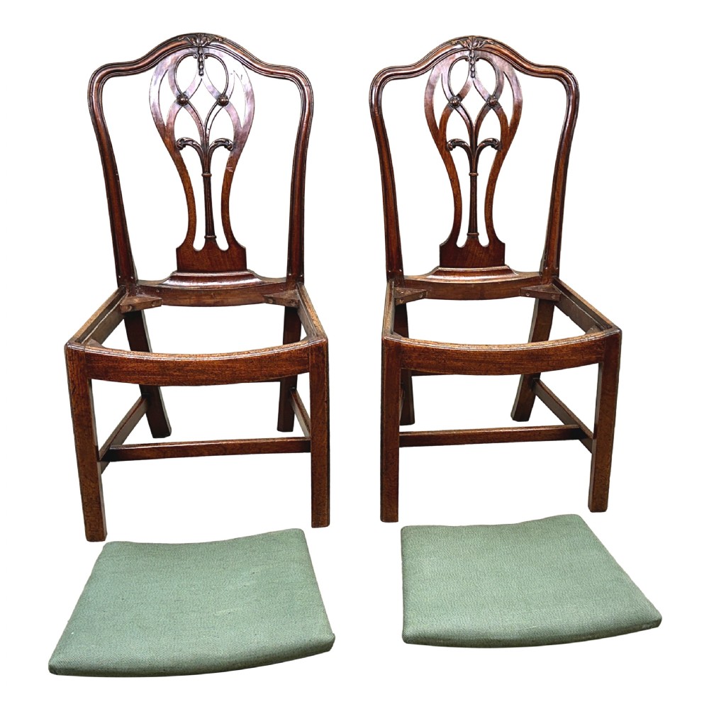 A pair of 18th-century Georgian mahogany side chairs featuring pierced back splats, serpentine top rails, and light green upholstered drop-in seats. View IX